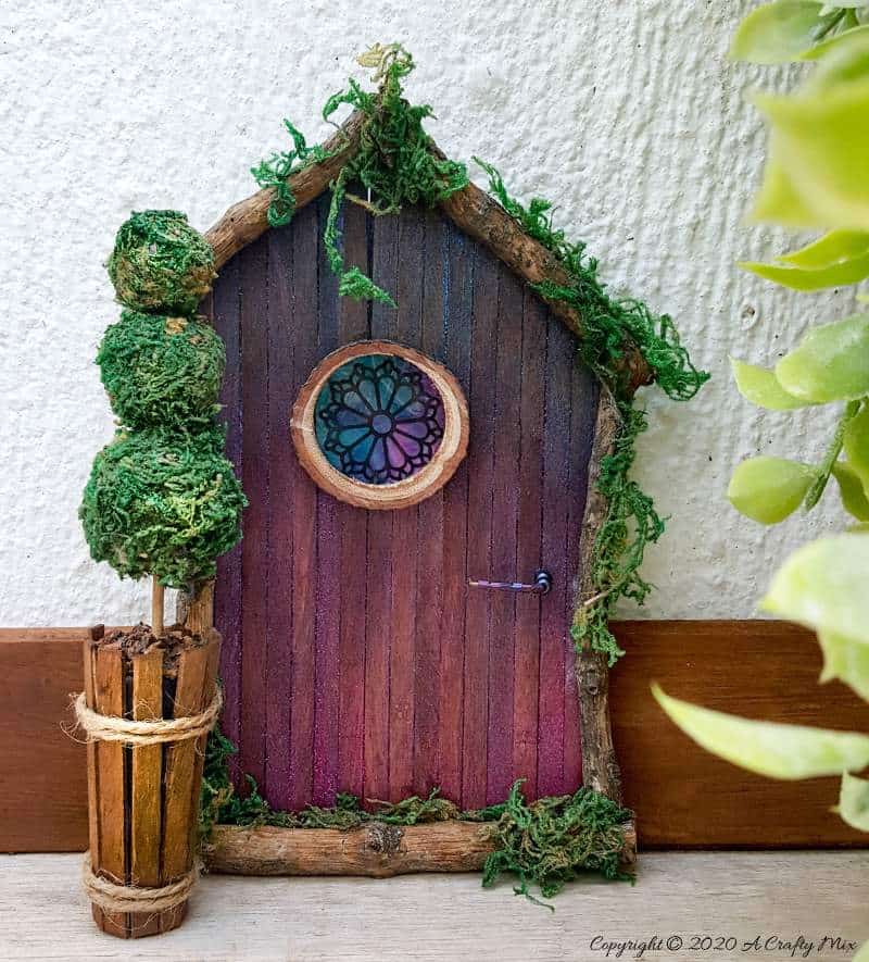 Welcome the fae folk into your home with this gorgeous stained glass fairy door and miniature topiary #FairydoorDIY #FairyDoorIdeas #ACraftyMix #MakeAFairyDoor #MiniatureStainedGlass #AlcoholInk