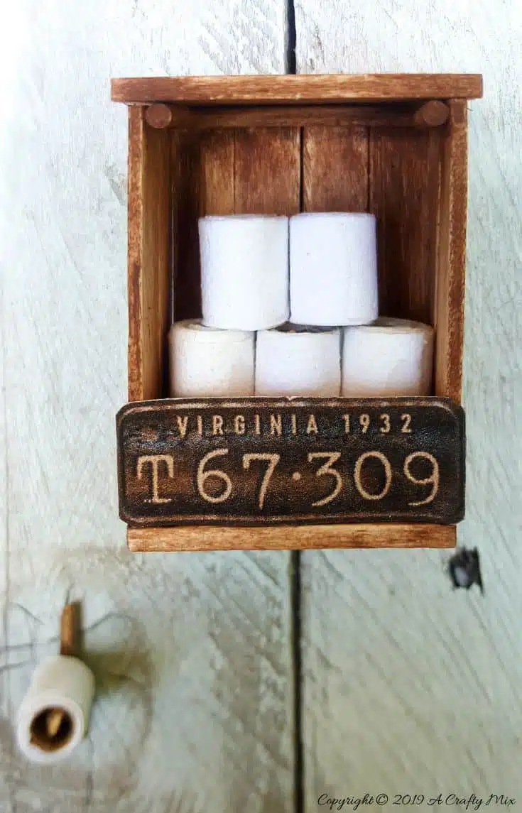 If you’re looking to make something unique for your doll’s house you’re going to love this mini license plate toilet paper holder tutorial. It includes a video that will show you how to make tiny toilet rolls and there’s a free printable you can use to create the license plate. #DIYMiniatureToiletPaper #ToiletPaperStorage #ACraftyMix #MakingMiniatures #FairyToiletPaper #DollHouseCrafts