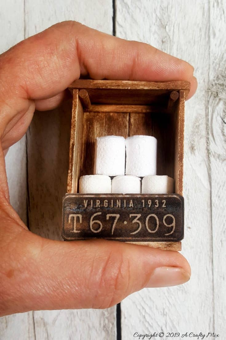 If you&rsquo;re looking to make something unique for your doll&rsquo;s house you&rsquo;re going to love this mini license plate toilet paper holder tutorial. It includes a video that will show you how to make tiny toilet rolls and there&rsquo;s a free printable you can use to create the license plate. #DIYMiniatureToiletPaper #ToiletPaperStorage #ACraftyMix #MakingMiniatures #FairyToiletPaper #DollHouseCrafts