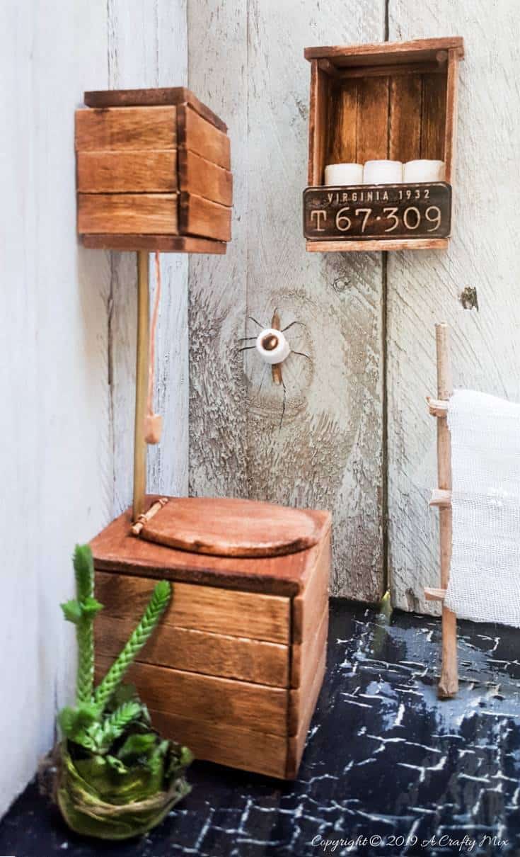 If you&rsquo;re looking to make something unique for your doll&rsquo;s house you&rsquo;re going to love this mini license plate toilet paper holder tutorial. It includes a video that will show you how to make tiny toilet rolls and there&rsquo;s a free printable you can use to create the license plate. #DIYMiniatureToiletPaper #ToiletPaperStorage #ACraftyMix #MakingMiniatures #FairyToiletPaper #DollHouseCrafts