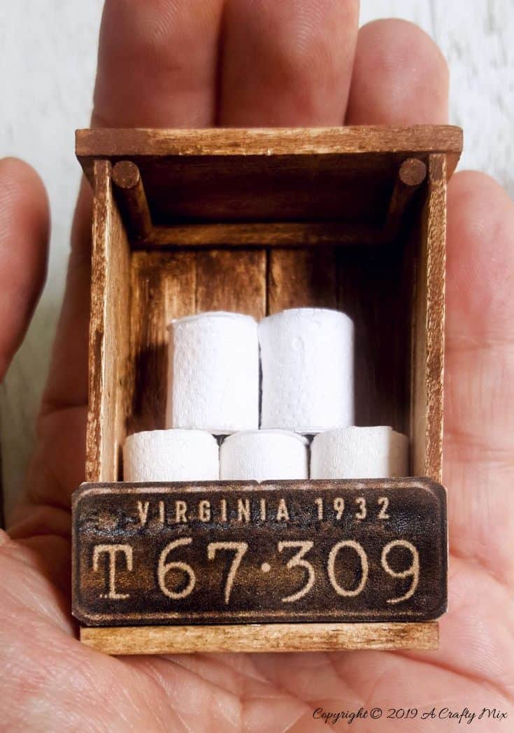If you’re looking to make something unique for your doll’s house you’re going to love this mini license plate toilet paper holder tutorial. It includes a video that will show you how to make tiny toilet rolls and there’s a free printable you can use to create the license plate. #DIYMiniatureToiletPaper #ToiletPaperStorage #ACraftyMix #MakingMiniatures #FairyToiletPaper