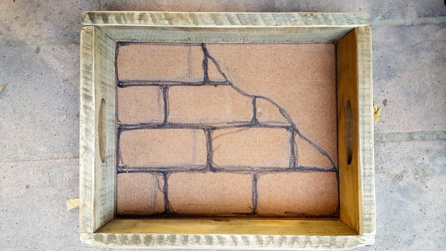 Draw brick shapes inside the shadow box and cut mason board to size