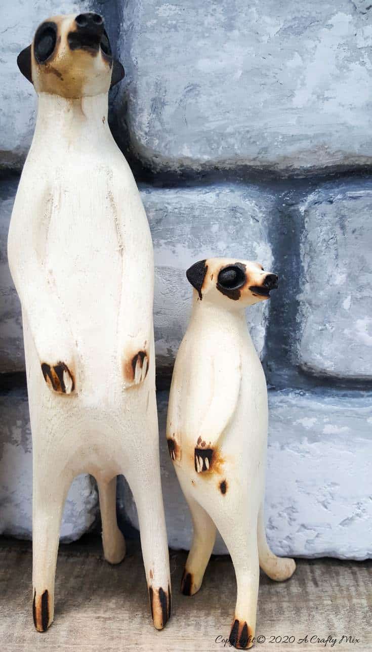 Two little wooden meerkats in a faux brick lined shadow box. A easy DIY #FauxBricksDIY #DisplayBoxDIY #ACraftyMix #BrickWallDisplaybox #DIYHomeDecor #FramedBricks