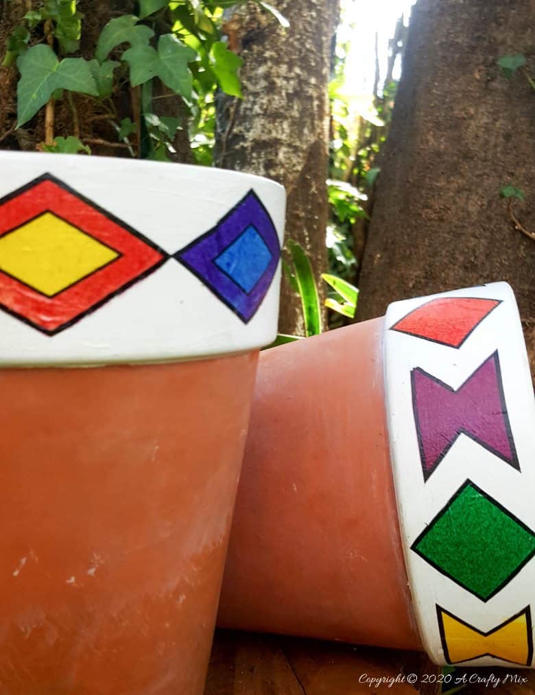 Add a little African magic to your garden with these gorgeous Ndebele planters that take less than 10 minutes to make. The full tutorial includes a set of free printables to make your own. #ndebelepattern #ndebeleart #ndebeleplanter #acraftymix #localislekker #DIYPlanter