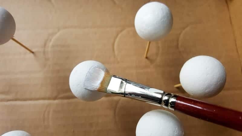 Using a white acrylic paint cover the balls entirely