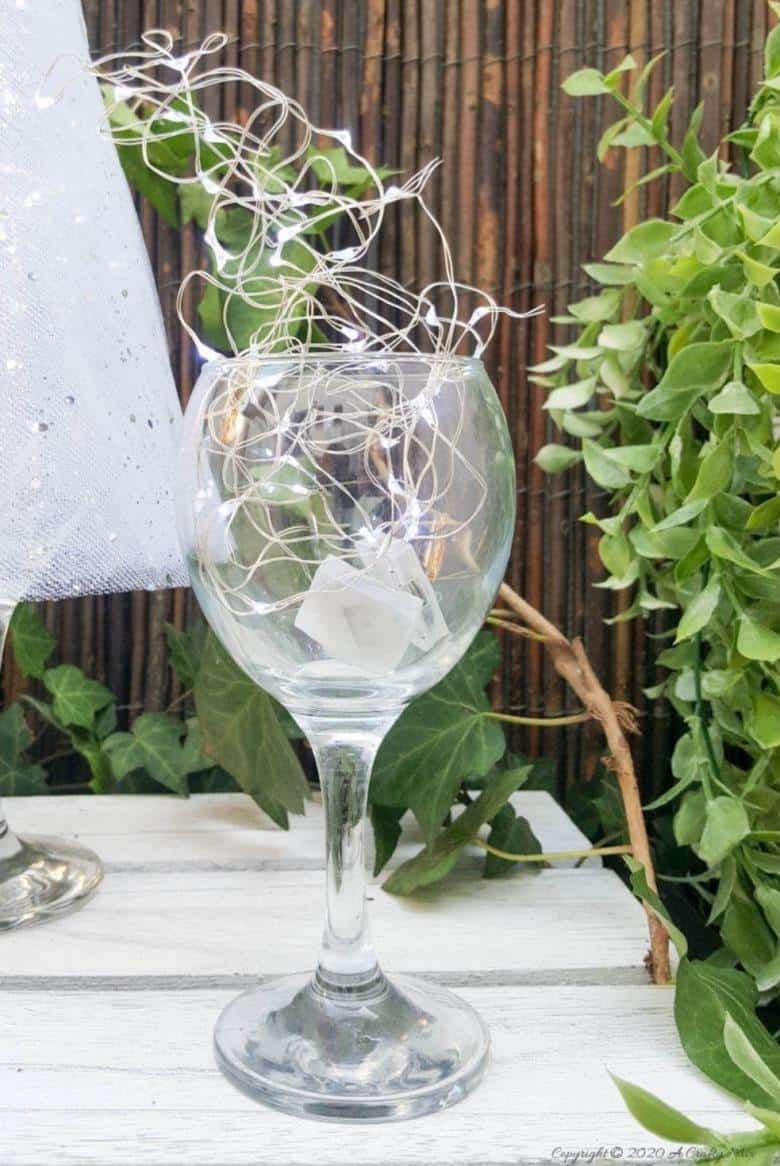 Insert fairy lights into the goblet of the wine glass and switch them on