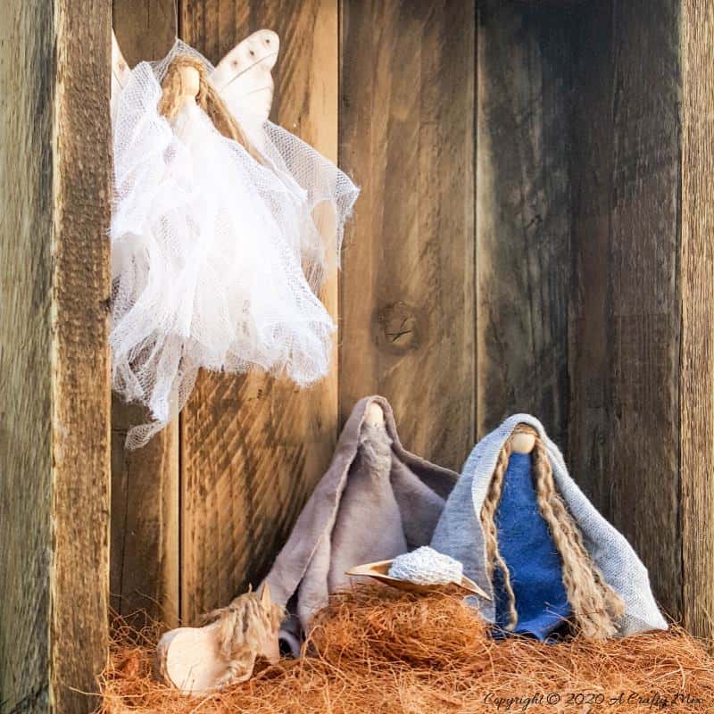 This easy to follow tutorial with show you how to make a rustic clothespin Nativity scene out of fabric scraps and wooden pegs. The tutorial includes a &ldquo;free to download&rdquo; printable for the angel wings. #ClothesPinCrafts #DIYNativity #WoodenPegCrafts #ACraftyMix #ChristmasCrafts #NativityScene