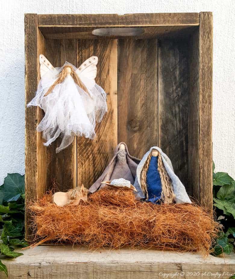 This easy to follow tutorial with show you how to make a rustic clothespin Nativity scene out of fabric scraps and wooden pegs. The tutorial includes a “free to download” printable for the angel wings. #ClothesPinCrafts #DIYNativity #WoodenPegCrafts #ACraftyMix #ChristmasCrafts #NativityScene
