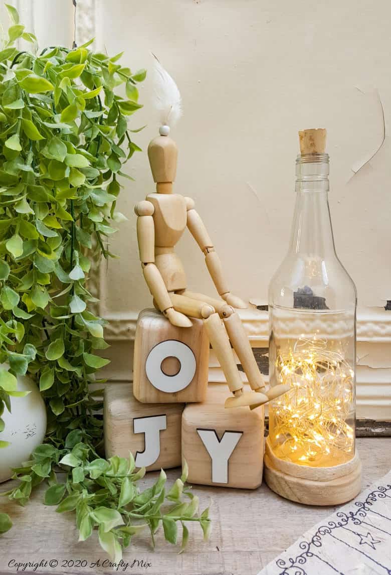 Take your glass bottle light to a whole new level with this DIY idea. A quick and easy way to repurpose and customize ONE bottle to fit any occasion or season with swappable art inserts. And you&rsquo;ll have loads of fun coming up with new images to put inside too. #bottlelight #winebottlelights #acraftymix #bottlerepurpose #bottlecrafts