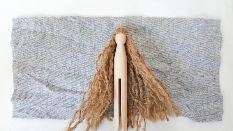 To make the cape, place the clothespin on the fabric on the half way mark