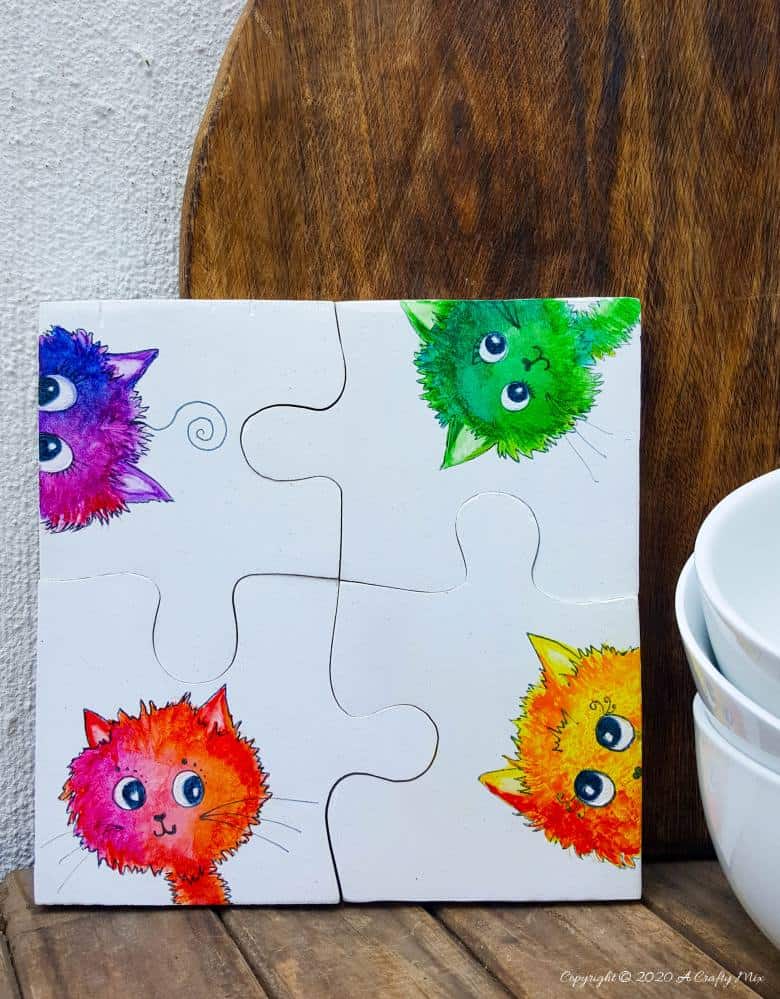 Best DIY Gift Idea EVER!!! Curious Kitty Puzzle Coasters that double up as a platter when you put them all together. The full tutorial will show you how to make your own and includes a free template for the puzzle as well as all four kitties. #PuzzleCoasters #DIYGiftIdea #ACraftyMix #PuzzlePlatter ##DIYPuzzle #FreePrintable
