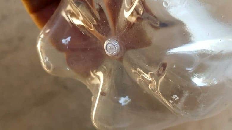 Make a few small holes in the bottom of the plastic soda bottles