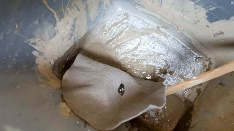 Put the fabric inside the slurry mix and drench to coat completely