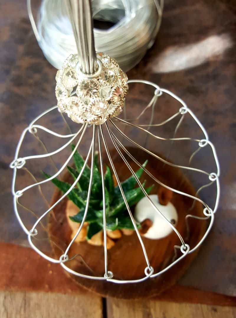 A beautiful crystal bead sits on top of the birdcage. This easy to follow tutorial will show you how to make your own art deco wire bird cage. Made in a morning, it&rsquo;s a fun way to add a little handcrafted glamour to you d&eacute;cor. #BirdCage #DIY #ACraftyMix