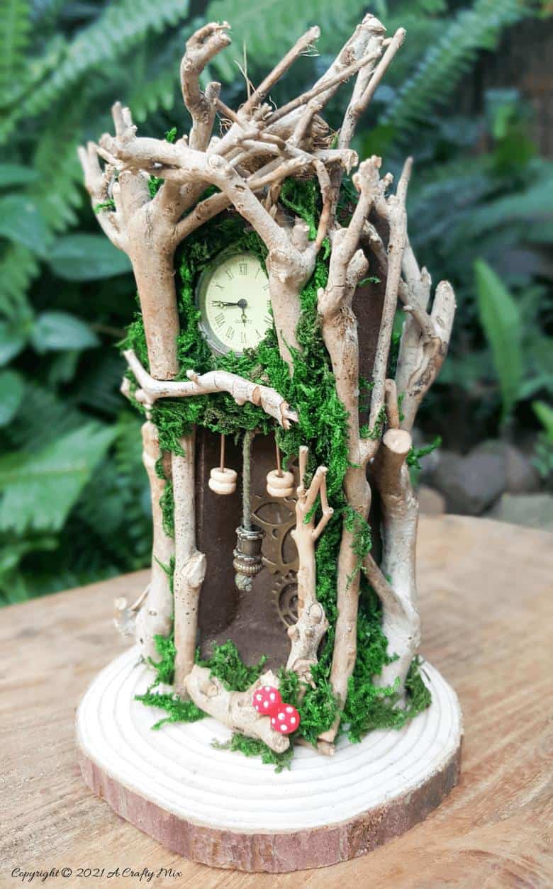 Have you ever wanted to make a real working fairy grandfather clock? This tutorial will show you how and includes a downloadable template along with instructions to make teeny, tiny mushrooms and a fairy bird&rsquo;s nest. #FairyCrafts #ACraftyMix #MiniatureGrandfatherClock