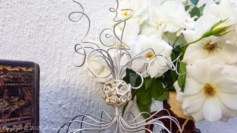 A beautiful crystal bead sits on top of the birdcage. This easy to follow tutorial will show you how to make your own art deco wire bird cage. Made in a morning, it&rsquo;s a fun way to add a little handcrafted glamour to you d&eacute;cor. #BirdCage #DIY #ACraftyMix