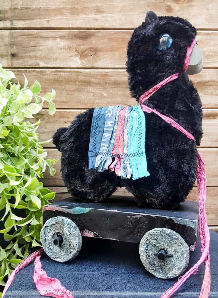 In the tradition of old toys we made this DIY Pull Toy llama using upcycled tin can wheels. This fun recycled craft idea comes with a free printable llama template. #Upcycle #TinCan #ACraftyMix #PullToy #HomeDecor