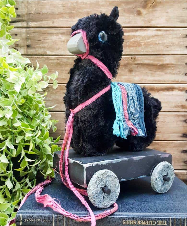 In the tradition of old toys we made this DIY Pull Toy llama using upcycled tin can wheels. This fun recycled craft idea comes with a free printable llama template. #Upcycle #TinCan #ACraftyMix #PullToy #HomeDecor