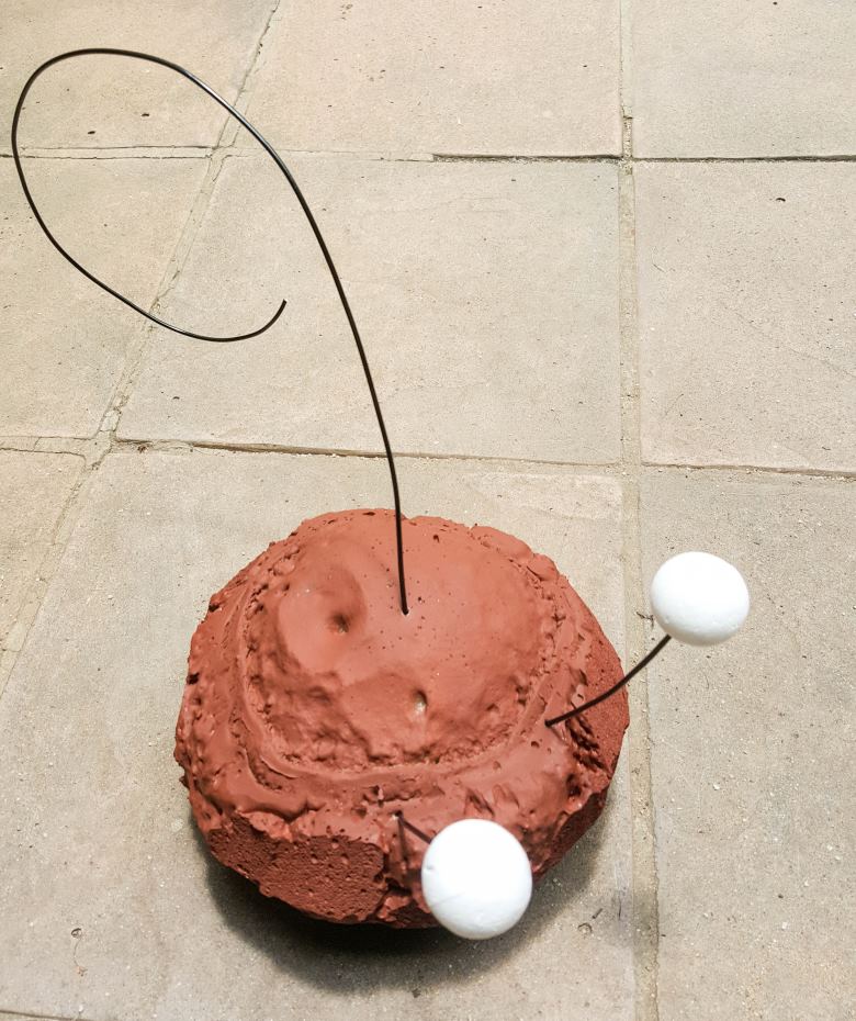 Insert the cut wire in the middle top of the blob for the hat and two shorter pieces towards the front for the eyes