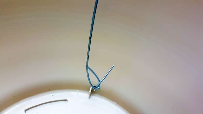 Twist the baling wire on the inside of the planter to secure the cup holder