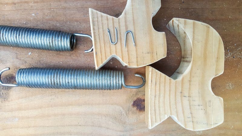 Use a fence post nail to attach the springs to the feet