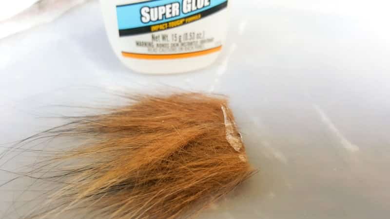 Put a line of clear drying glue on the cut edge of the fur