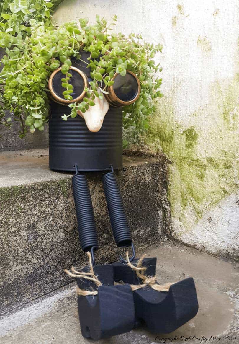 Looking for a creative way to repurpose a tin can? The you'll love this steampunk tin can planter. We call him Dr Edinose and he's sure to add a little whimsy to your outdoor decor. #steampunkplanter #ACraftyMix #TinCanRecycle