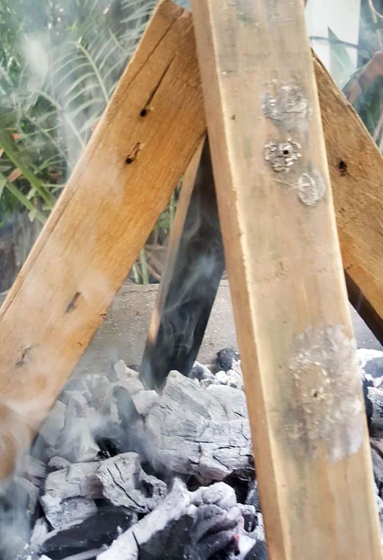 Stack the wood pieces in a teepee shape over a hot fire