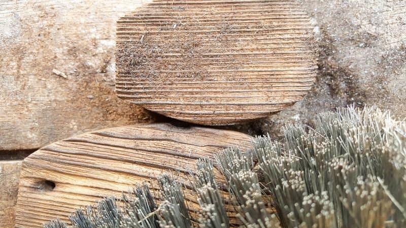 Use a wire brush or 60 grit sandpaper to remove the charred wood