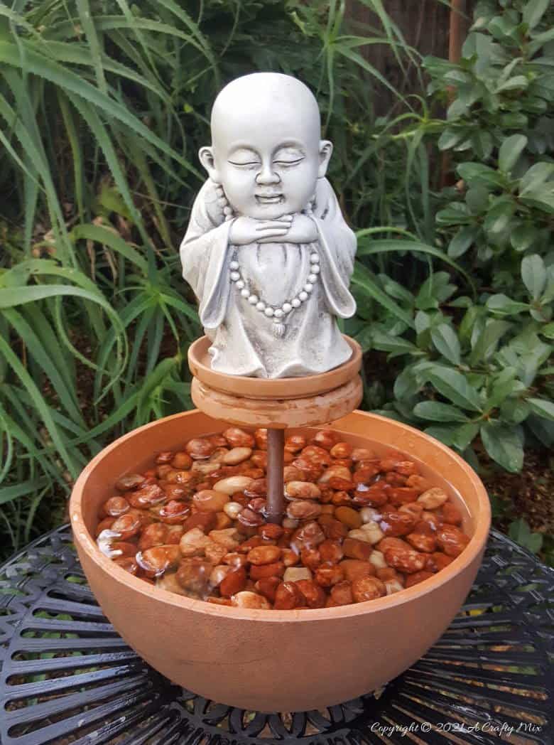 This photo-rich tutorial will show you how just how easy it is to repurpose an empty CD case and turn it in a CD spindle water feature bringing a calming, zen-like decorative feel to any space. #Spindlerepurpose #ACraftyMix #waterfeature