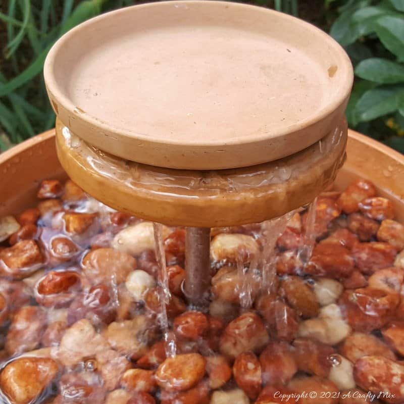 This photo-rich tutorial will show you how just how easy it is to repurpose an empty CD case and turn it in a CD spindle water feature bringing a calming, zen-like decorative feel to any space. #Spindlerepurpose #ACraftyMix #waterfeature