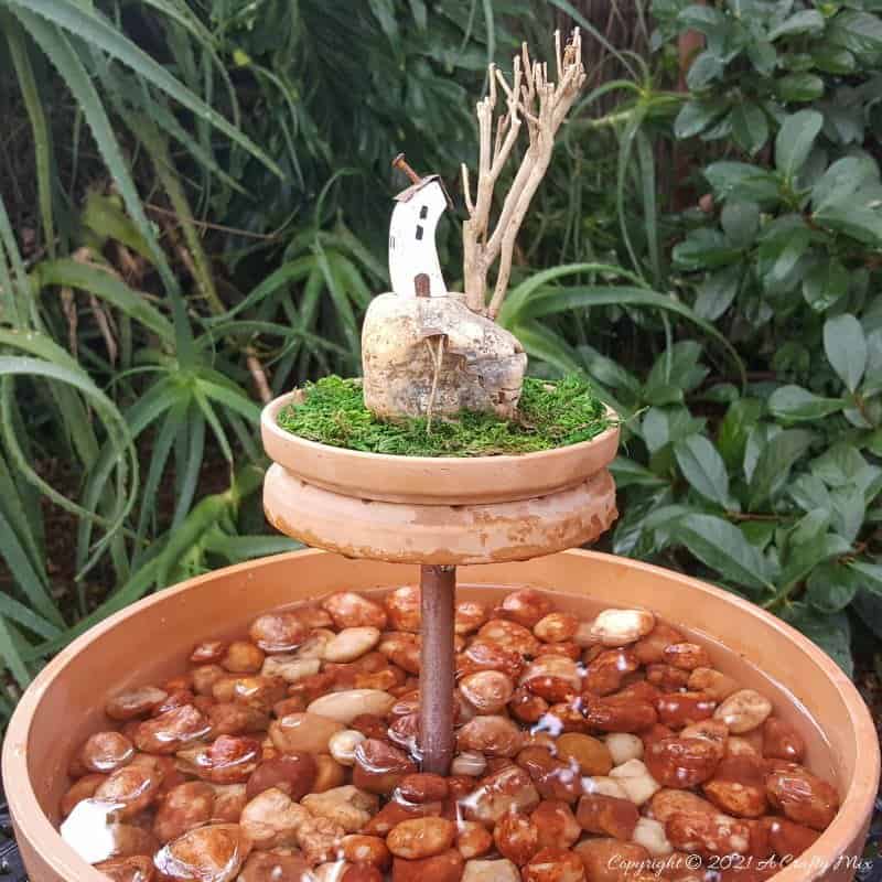 This photo-rich tutorial will show you how just how easy it is to repurpose an empty CD case and turn it in a CD spindle water feature bringing a calming, zen-like decorative feel to any space. #Spindlerepurpose #ACraftyMix #waterfeature
