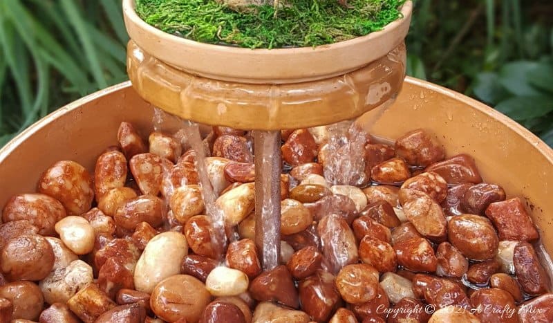 This photo-rich tutorial will show you how just how easy it is to repurpose an empty CD case and turn it in a CD spindle water feature bringing a calming, zen-like decorative feel to any space. #Spindlerepurpose #ACraftyMix #waterfeature