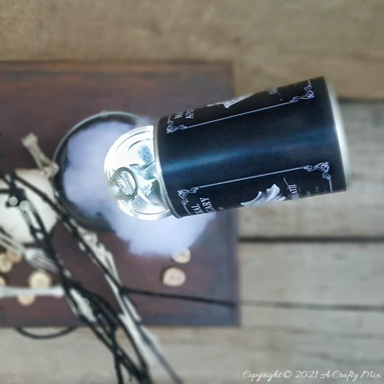 Add a little fun and mystery to your Halloween decor with this easy-to-make magical floating tin can filled with ghost breath. You don't need any special tools and it takes less than an hour to make too. #HalloweenDecor #HalloweenCrafts #ACraftyMix #FloatingTinCan