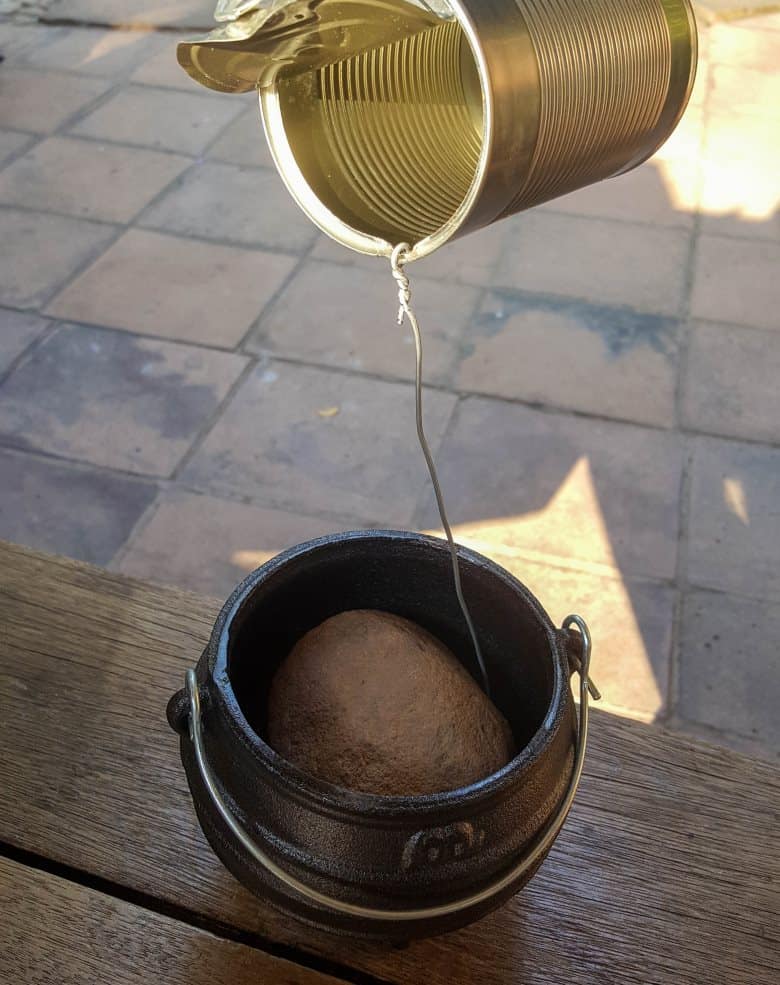 Place the twirled wire inside a pot and weigh down with a large pebble