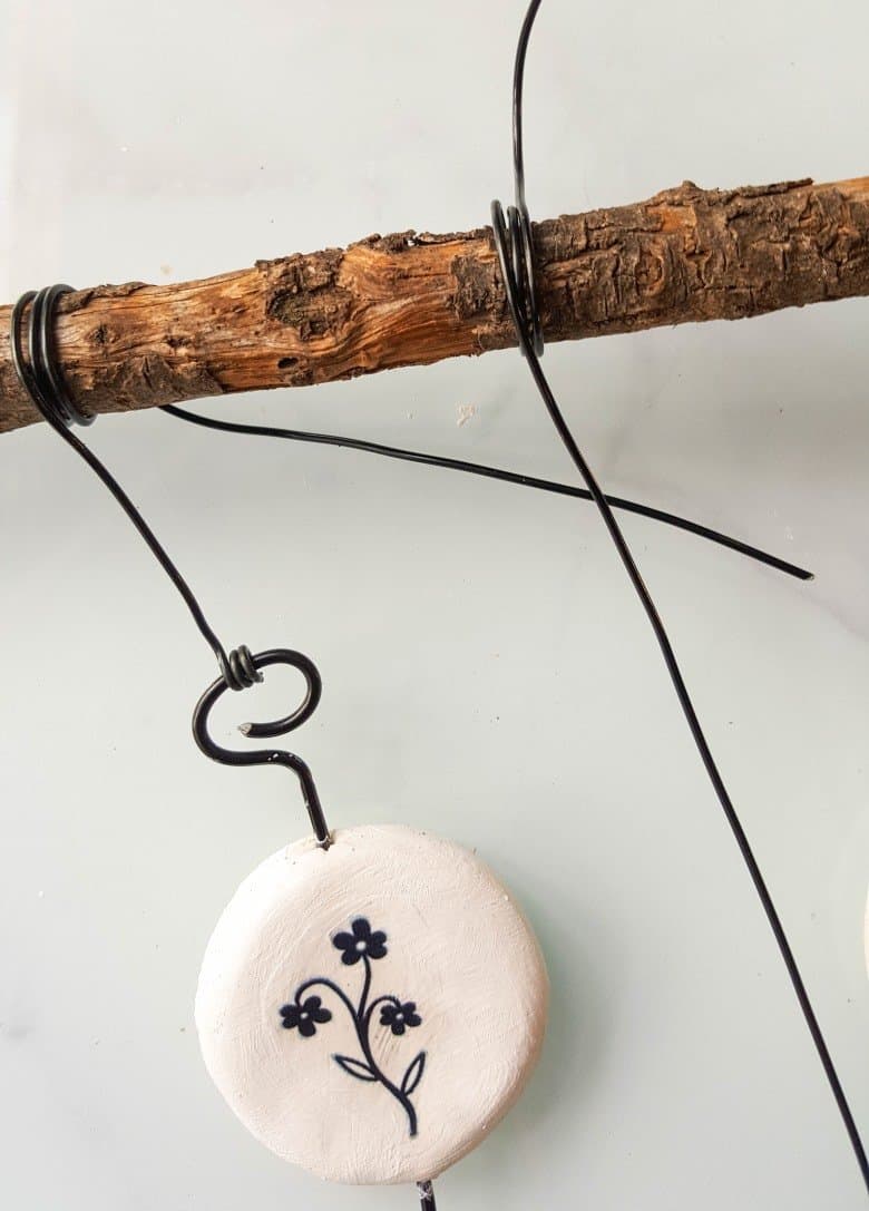 Twist a piece of wire around a branch to hang the tattooed clay discs