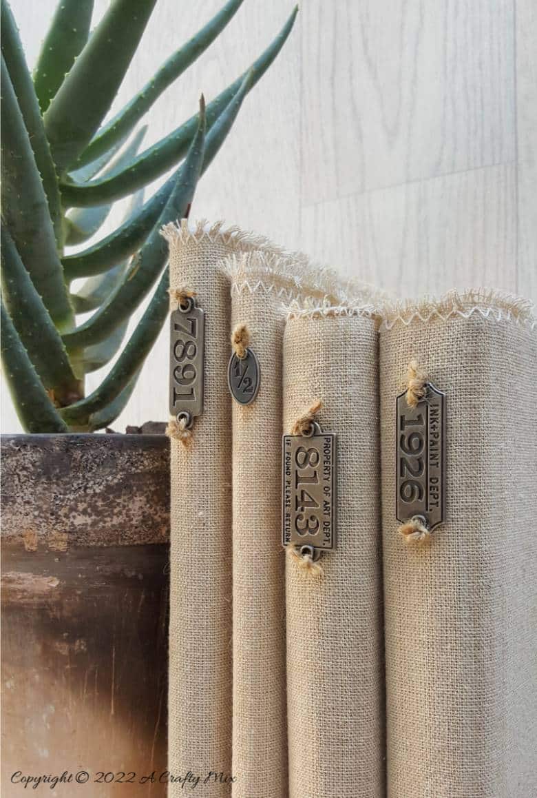 Do you like making a stylish statement while indulging your reading obsession? Then you&rsquo;re going to love these easy to make linen book covers with metal tags. Not only can you dress up your old or new books up in new attire, but you can customise the tutorial to suit your d&eacute;cor style. #DIYBookCovers #ACraftyMix #StylishBooks