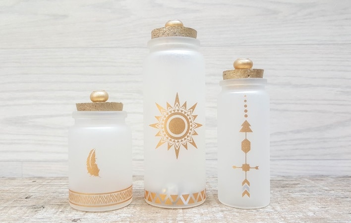 A perfect beginner-friendly home decor project that only takes a few minutes to make! These gorgeous glass bottle lights with gold accents look lovely no matter where you display them. Place them on your mantle or bookshelf or use them as a centerpiece at a special event or bridal shower. #DIYBottleDecor #ACraftyMix #GlassBottleIdeas