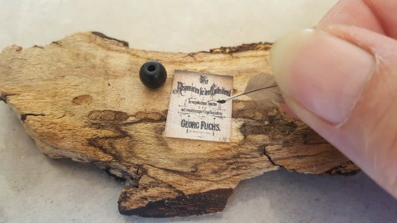 Miniature quill and ink pot on the table