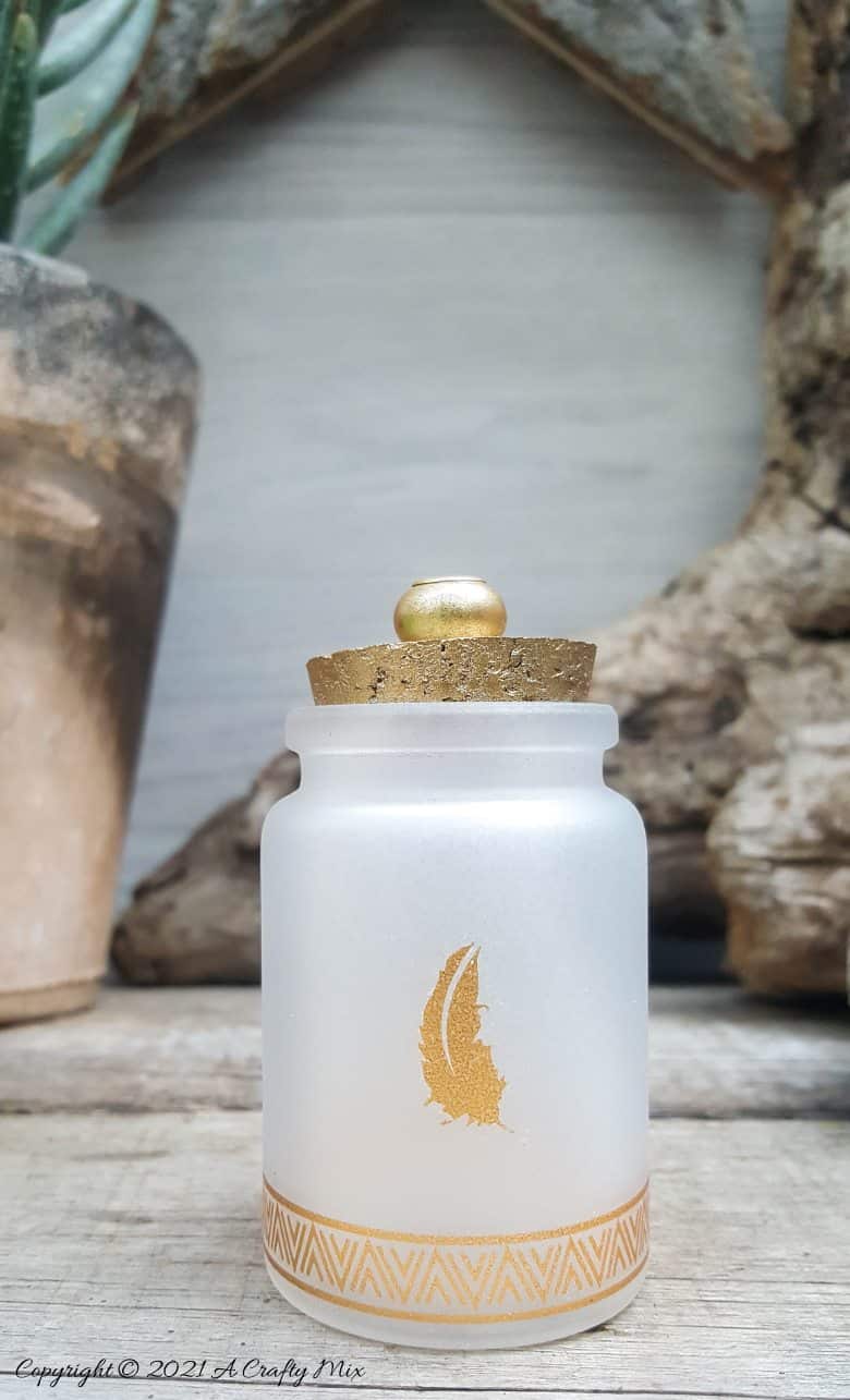 A perfect beginner-friendly home decor project that only takes a few minutes to make! These gorgeous glass bottle lights with gold accents look lovely no matter where you display them. Place them on your mantle or bookshelf or use them as a centerpiece at a special event or bridal shower. #DIYBottleDecor #ACraftyMix #GlassBottleIdeas