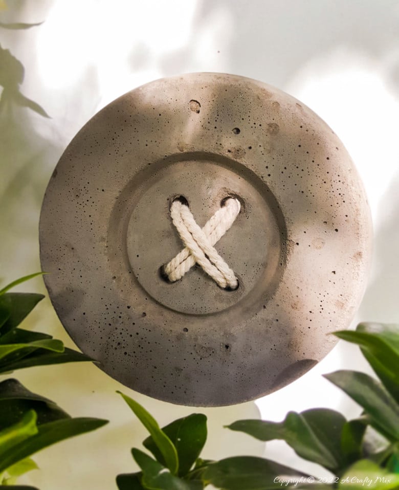 This tutorial will show you how to make BIG concrete buttons that will add a uniquely rustic touch to your home. Use them to decorate your craft room, laundry or anywhere you want to hang a few of your favorite things. #HomeDecor #ACraftyMix