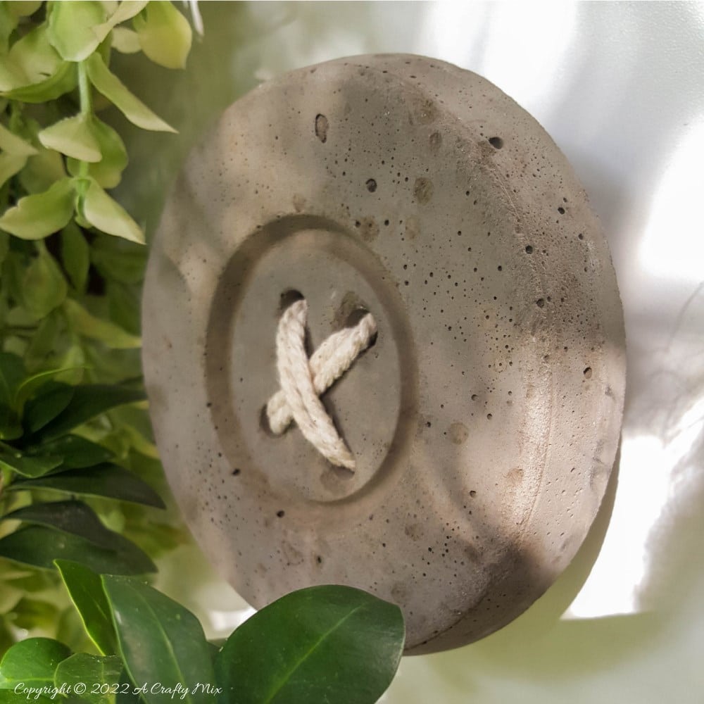 This tutorial will show you how to make BIG concrete buttons that will add a uniquely rustic touch to your home. Use them to decorate your craft room, laundry or anywhere you want to hang a few of your favorite things. #HomeDecor #ACraftyMix