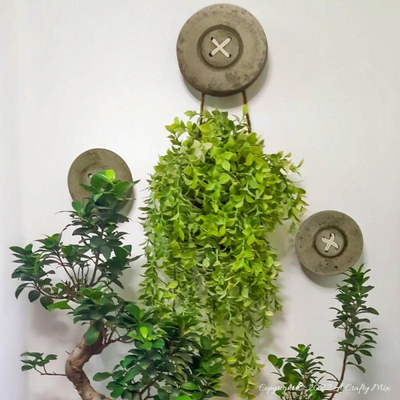 This tutorial will show you how to make BIG concrete buttons that will add a uniquely rustic touch to your home. Use them to decorate your craft room, laundry or anywhere you want to hang a few of your favorite things. #HomeDecor #ACraftyMix
