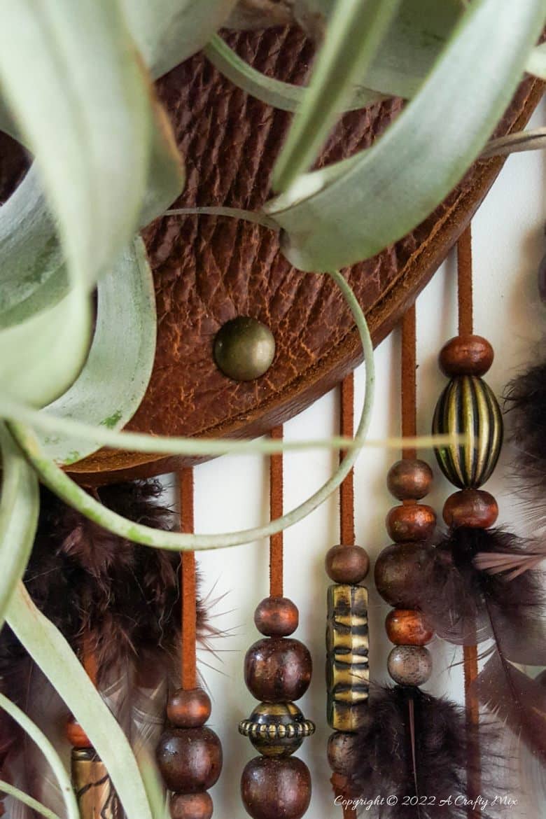 Do you enjoy making planters that serve a dual purpose? We sure do. I've been nurturing a rather large air plant for a while and wanted to make something that would put her center stage and add a little boho magic to our decor. And I think I may have done just that with this leather Tillandsia planter. Get the full tutorial here. #diyairplanter #AcraftyMix #livingwalldecor