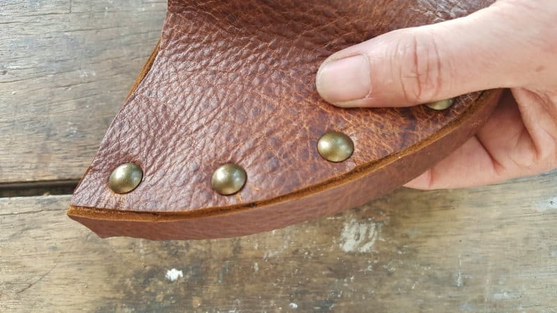 Glue a leather strip around the edge of the cut board
