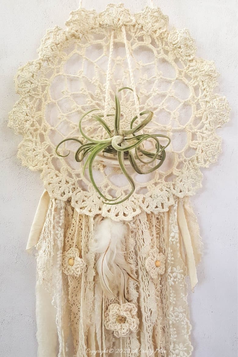 Looking for a charming way to incorporate plants in your décor? This repurposed doily air plant holder is quick and easy to make and can be hung anywhere to add a little natural greenery to your home. #ACraftyMix #BrokenTerraCotta #GreenWallDecor