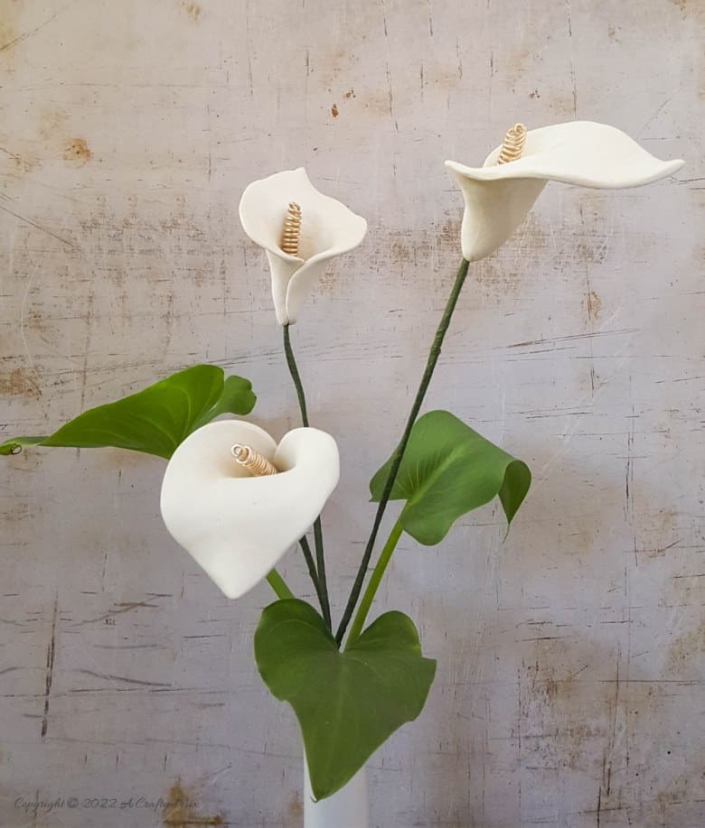 Quick and easy to make, these clay arum lilies with a curly wire spadix are striking on their own or grouped together in a bouquet. Detailed tutorial on the blog with of step-by-step photos and video. #acraftymix #arum #calla