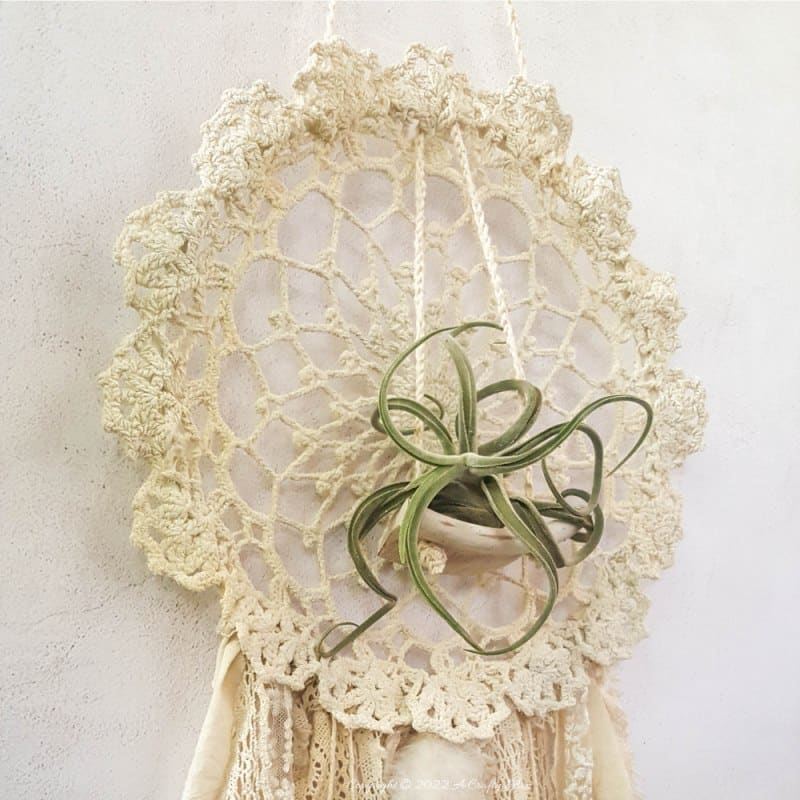 Looking for a charming way to incorporate plants in your d&eacute;cor? This repurposed doily air plant holder is quick and easy to make and can be hung anywhere to add a little natural greenery to your home. #ACraftyMix #BrokenTerraCotta #GreenWallDecor