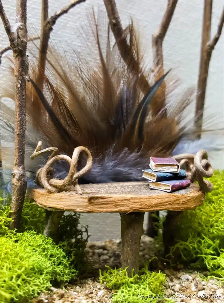 A close up of a stack of tiny books on the feathered fairy throne