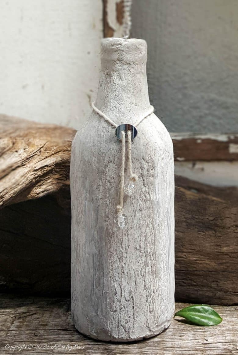 I put my large wire flower inside a plain glass bottle that's been covered in charcoal ash texture paste
